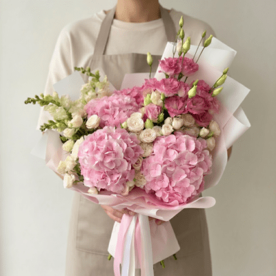 Mother’s Day bouquet with pink hydrangeas, blush flowers, and white roses in soft pink wrapping