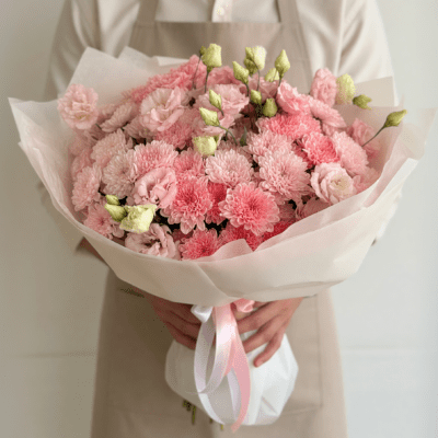 Mother’s Day bouquet with soft blush pink flowers in a full, cloud-like arrangement wrapped in white paper