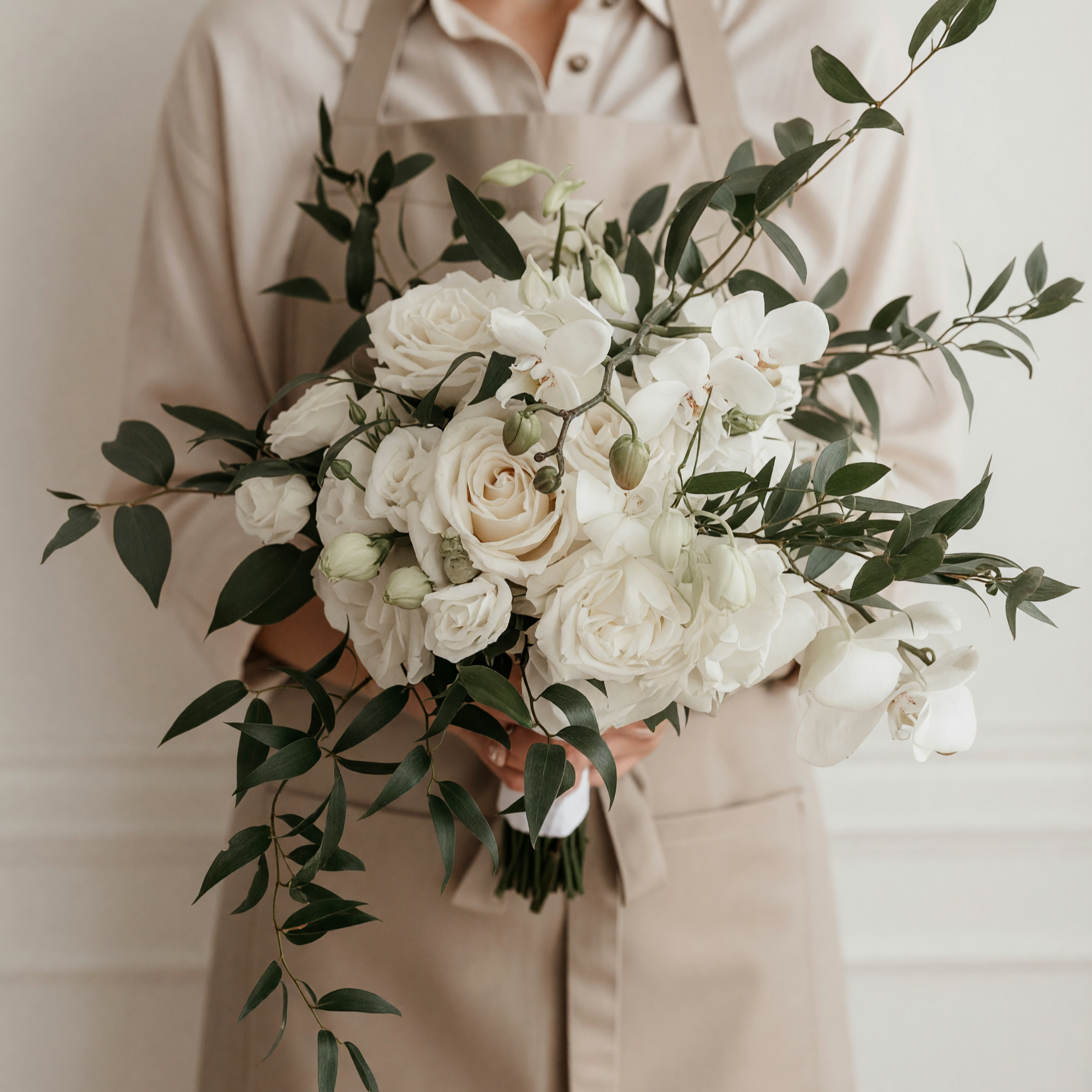 Beach Wedding Bouquets arrangement featuring ivory roses, white phalaenopsis orchids, unopened buds, and long cascading green branches