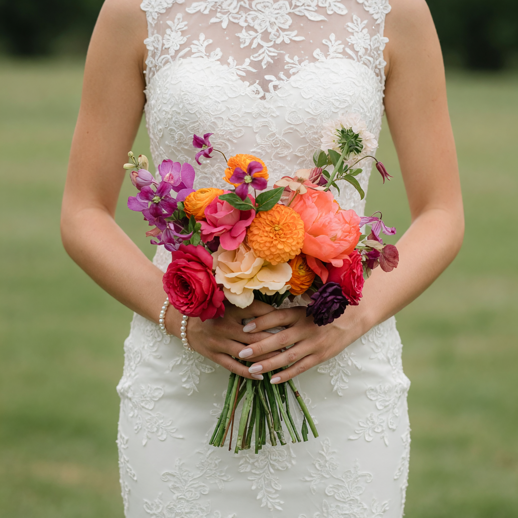 Bridal flowers bouquets with coral peonies, crimson roses, orange pompon dahlias, ranunculus, purple stock flowers, and seasonal wedding blooms.