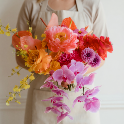 Bridal flowers bouquets featuring coral peonies, cascading pink orchids, anthuriums, roses, dahlias, and colourful tropical wedding flowers arranged in a luxury bridal bouquet