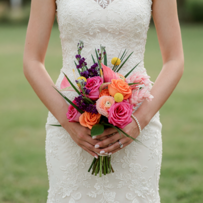Bridal flowers bouquets with coral and hot pink roses, purple flowers, yellow accents and fresh greenery for a colourful wedding.