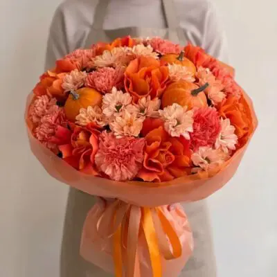Orange flowers Vancouver Pumpkin Spice bouquet with orange roses, coral carnations, peach flowers and miniature pumpkins in tonal wrapping.