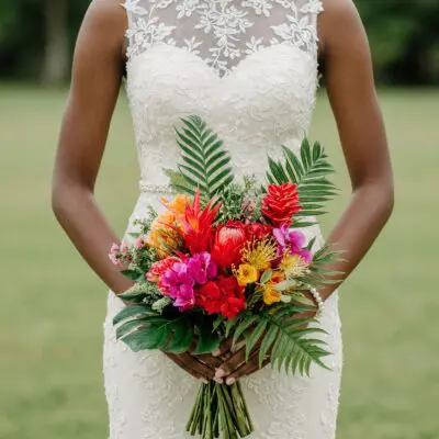 bridal blooms with scarlet tropical flowers red ginger protea orchids golden accents monstera leaves and palm foliage for a tropical bride