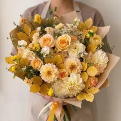 Yellow flowers Vancouver Butterscotch bouquet with cream and apricot roses, pale yellow dahlias, golden foliage and wheat-like accents.