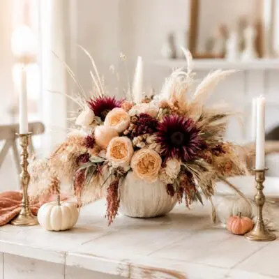 Autumn flower arrangement Vancouver with peach blooms, deep burgundy focal flowers, dried grasses and greenery in a neutral ceramic vase