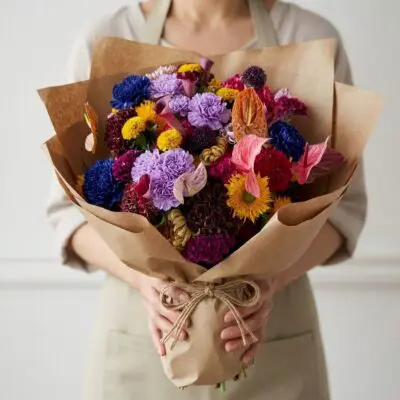 Colourful bouquet Vancouver with blue, lavender, pink, burgundy, coral and yellow flowers wrapped in natural kraft paper
