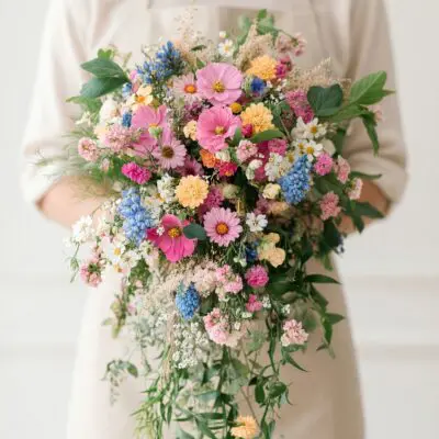 Bridal flowers bouquets with pink, blue, white and yellow wildflowers and cascading greenery for a romantic wedding