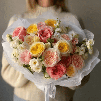 merrylen a lady holds a bouquet with pink yellow peach and crea 82dee454 1b30 4dbc 91c2 4daaf8c9e096