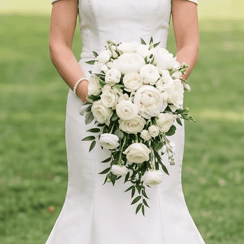 White Wedding Bouquet with white roses, white ranunculus, lisianthus, and fresh olive greenery in a romantic garden-style bridal arrangement.
