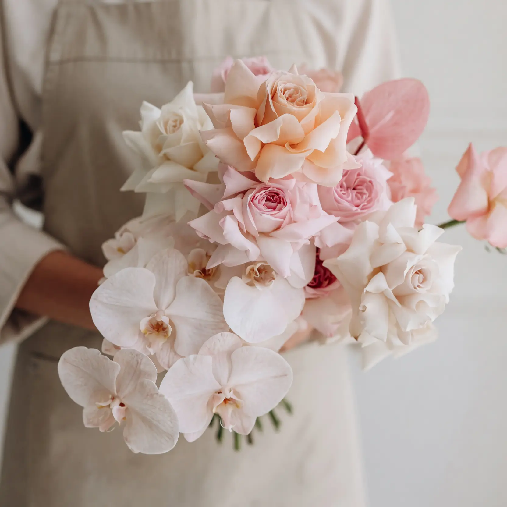 Pink Wedding Bouquet with blush roses, ivory roses, white phalaenopsis orchids, and pink anthurium among popular wedding bouquets