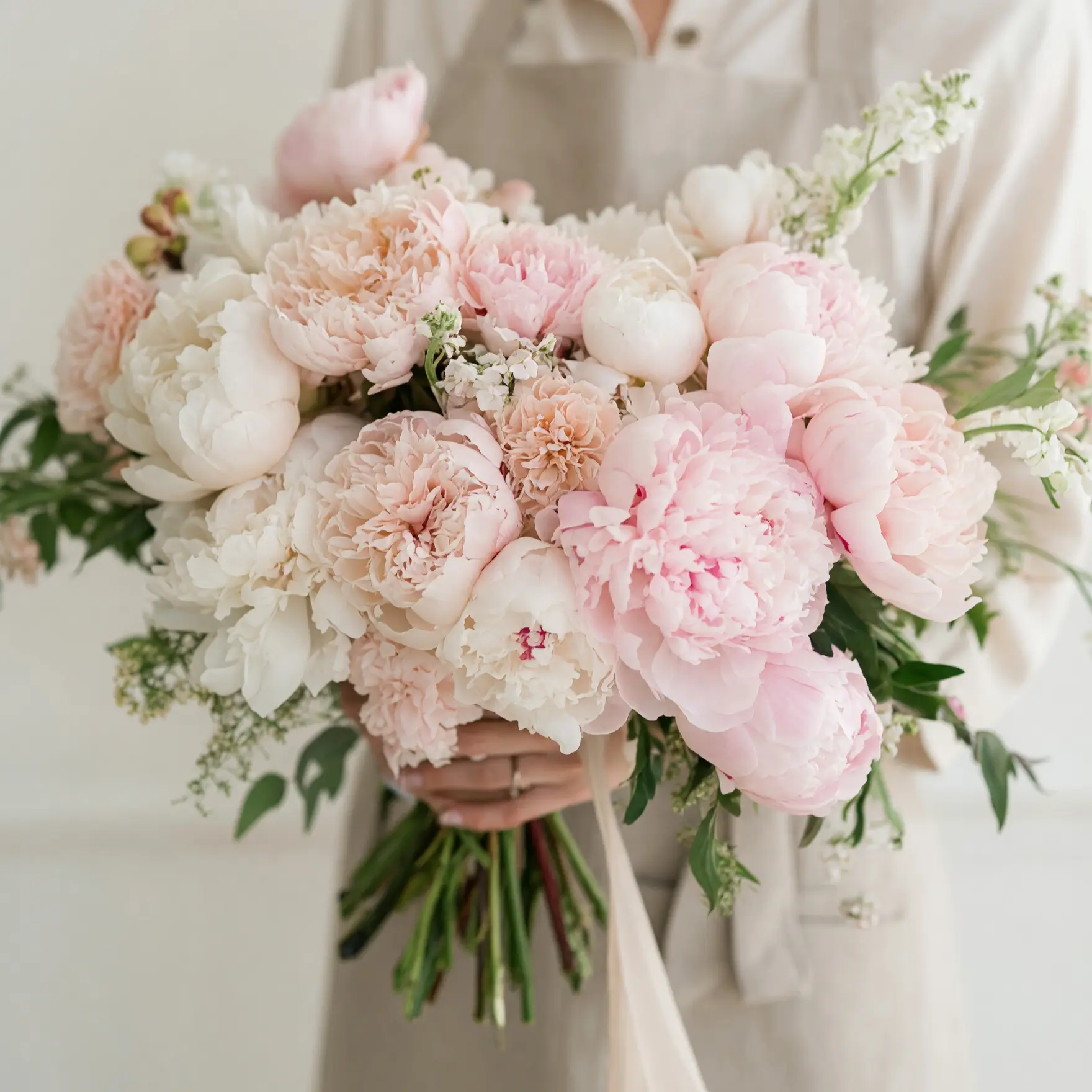 Pink Wedding Bouquet with blush peonies, ivory peonies, garden roses, carnations, and greenery among popular wedding bouquets