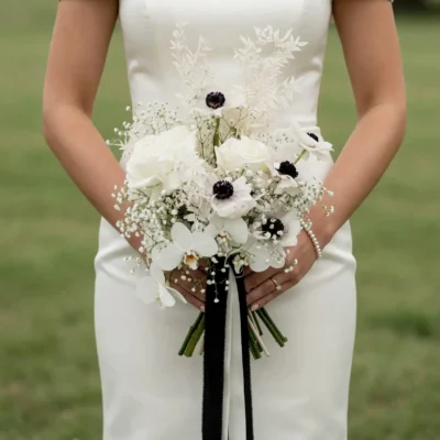 Anemone Wedding Bouquet featuring white roses, white orchids, black-centered anemones, baby's breath, preserved foliage, and elegant bridal flowers bouquets.