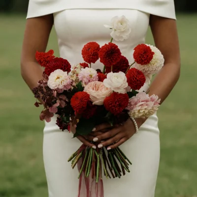 Red wedding bouquet with scarlet dahlias, blush roses, white ranunculus and romantic bridal flowers bouquets for elegant weddings