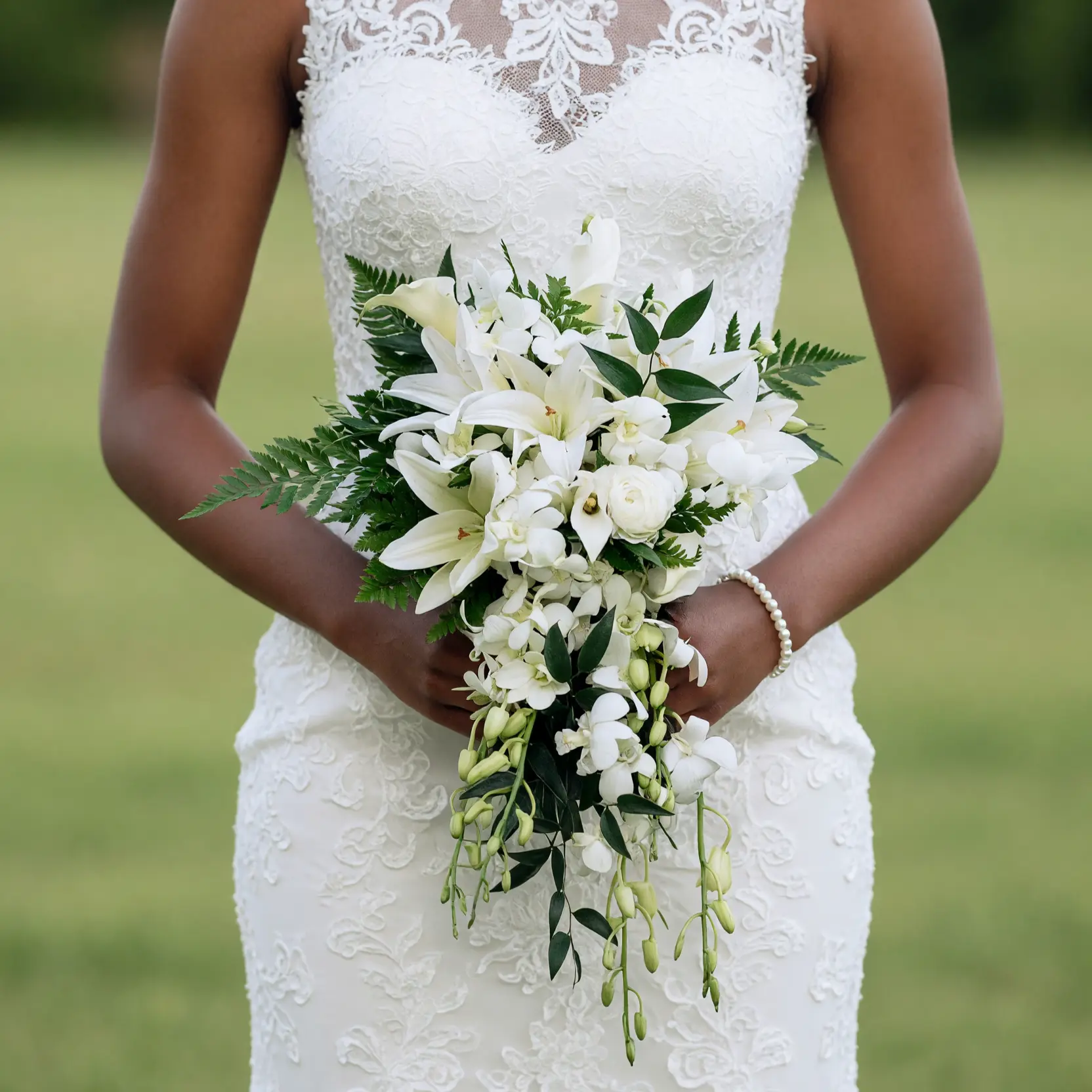 Beach Wedding Bouquets arrangement featuring white lilies, dendrobium orchids, ivory hydrangea, unopened buds, dark leaves, and fresh fern fronds