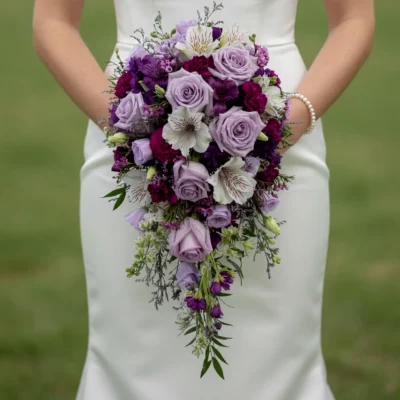 Purple Wedding Bouquets of lavender roses, deep plum blooms, white alstroemeria-like flowers and cascading greenery held by a bride