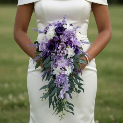 Purple Wedding Bouquets of violet roses, lavender flowers, white blooms and trailing green foliage held by a bride