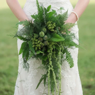 Boho style flowers greenery wedding bouquet with lush ferns, poppy seed pods, cascading amaranthus, and woodland foliage