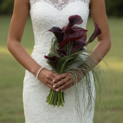 Boho style flowers bridal bouquet with burgundy calla lilies and cascading ornamental grasses for a modern wedding