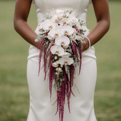 Bridal flowers bouquets featuring cascading white orchids, ivory roses, burgundy amaranthus, eucalyptus, and elegant wedding greenery.