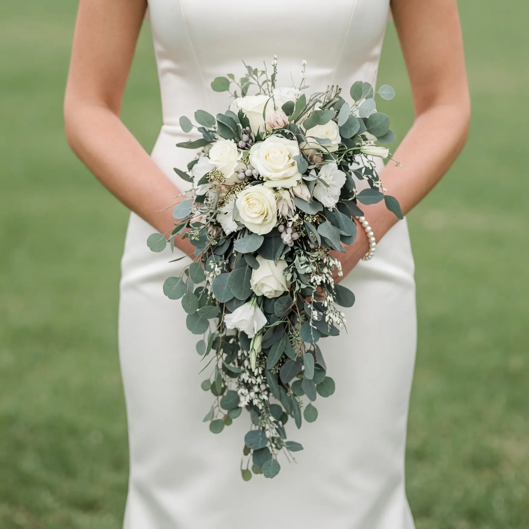 Bridal flowers bouquets with cascading white roses, silver eucalyptus, ivory flowers, and elegant greenery for timeless wedding style.