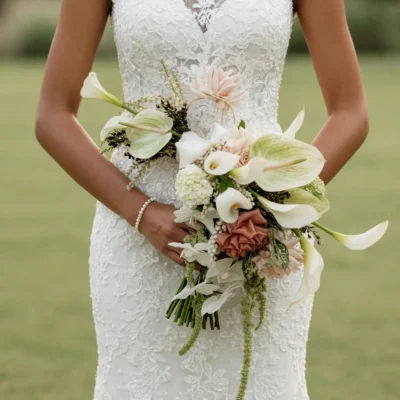 Romantic bridal blooms with blush flowers, ivory calla lilies and trailing greenery for a wedding bouquet