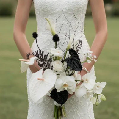 Bridal blooms with white orchids, calla lilies, black foliage, and dramatic floral accents in a modern black and white wedding bouquet