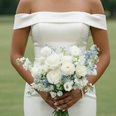 bridal flowers bouquets with creamy white roses pale blue flowers delicate white blooms and fresh greenery held by a bride