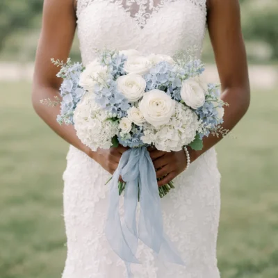 Popular wedding bouquets with white roses pale blue hydrangeas and flowing blue ribbon