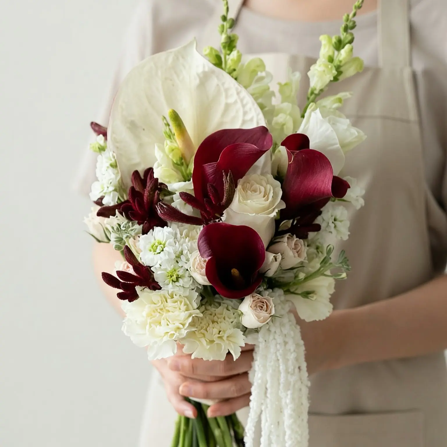 Bridal flowers bouquets with burgundy calla lilies, ivory roses, white hydrangeas, and elegant wedding flowers