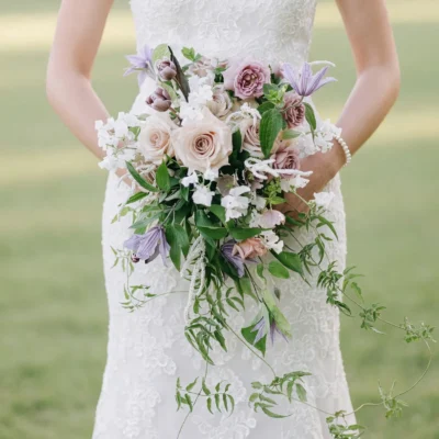 popular wedding bouquets with blush roses, ivory flowers, lavender blooms and cascading greenery held by a bride