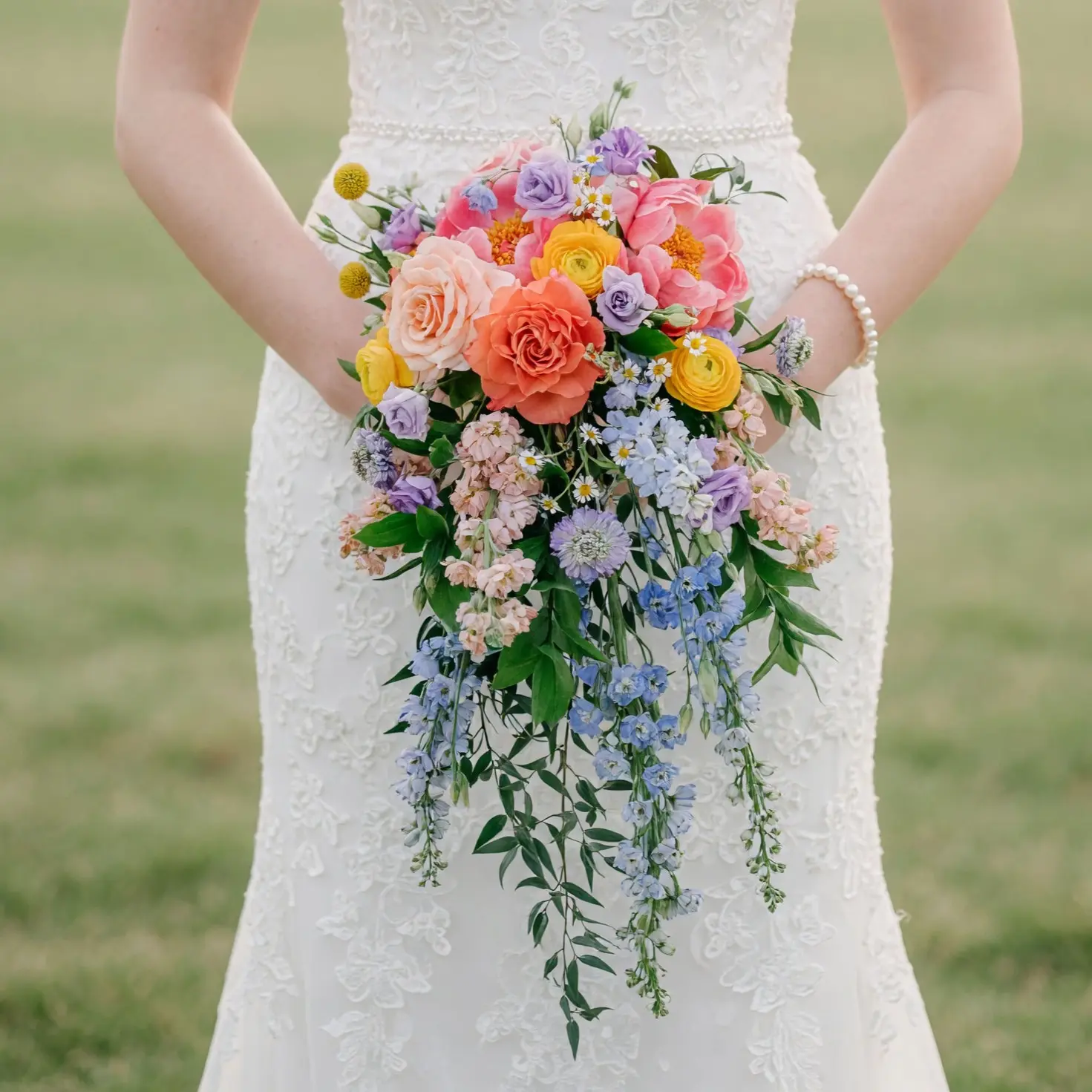 bridal flowers bouquets with coral roses yellow blooms lavender flowers blue cascading accents and greenery for a colorful garden wedding