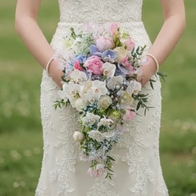 popular wedding bouquets with blush peonies white orchids blue hydrangea ivory roses and cascading greenery for a romantic bride