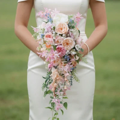 bridal blooms with blush roses ivory flowers pink blossoms blue accents and cascading greenery for a romantic garden wedding