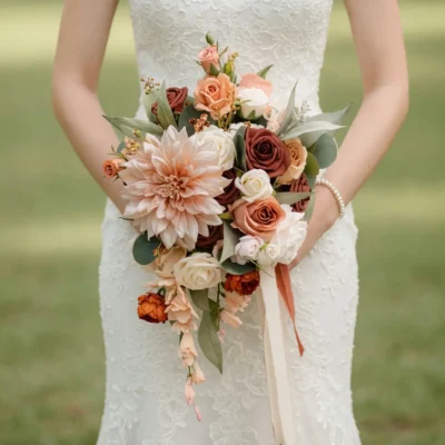 Bridal flowers bouquets with peach dahlia, ivory and cocoa roses, eucalyptus, trailing pale blooms, and ribbons for a romantic autumn bride