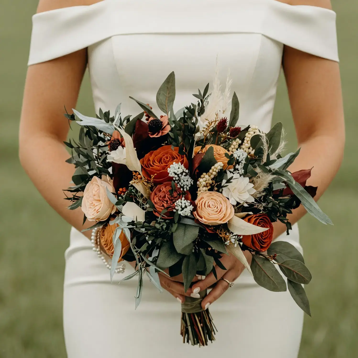 Popular wedding bouquets with rust and champagne roses, ivory flowers, eucalyptus, berries, dark foliage, and textured greenery for a fall bride