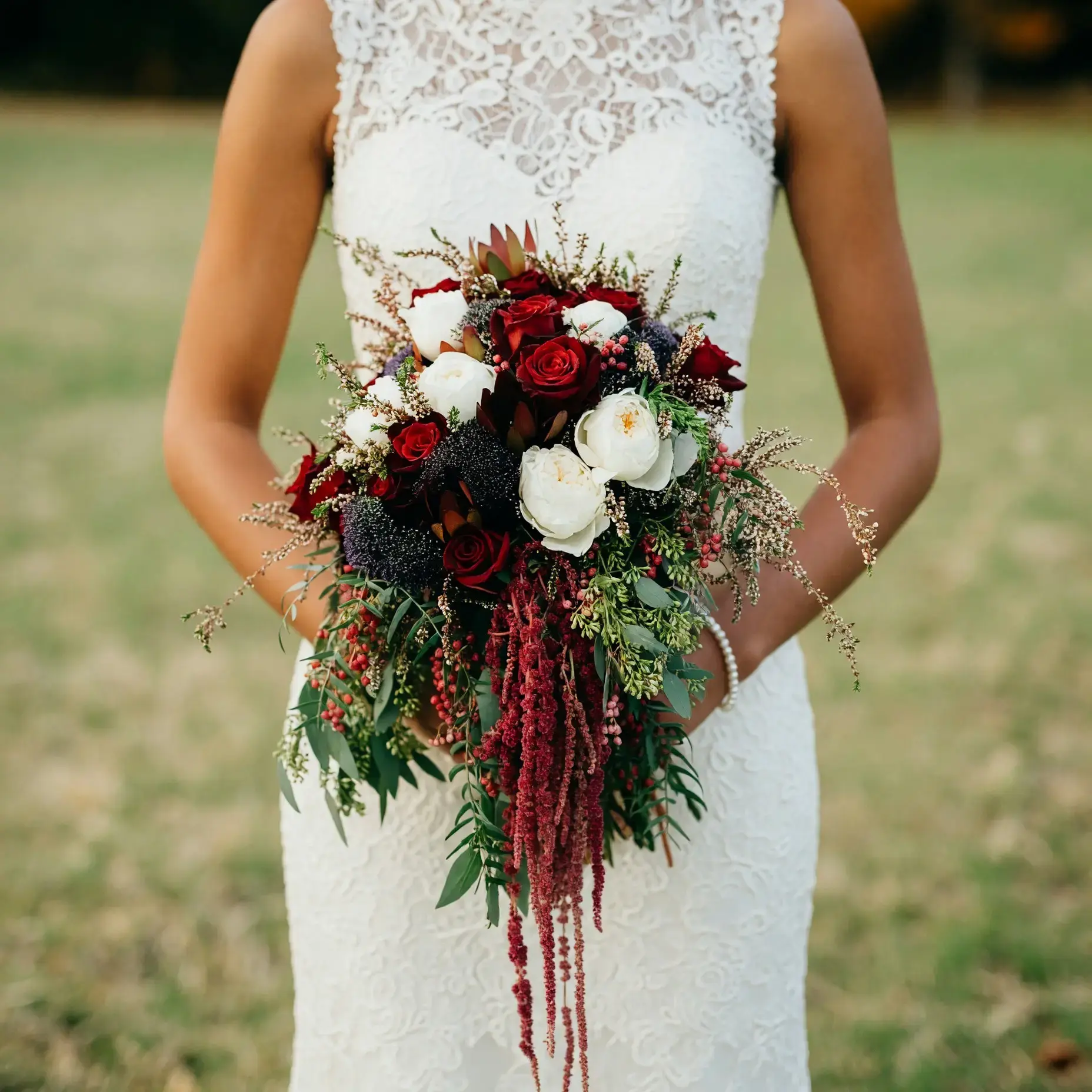 Bridal flowers bouquets with crimson roses, ivory blooms, dark berries, burgundy amaranthus, and cascading greenery for an elegant fall bride