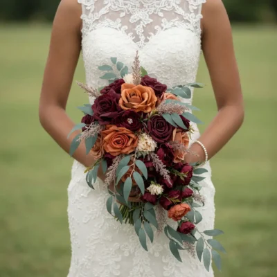 Bridal flowers bouquets with deep merlot and copper roses, eucalyptus, ivory botanical accents, and cascading foliage for an elegant fall bride