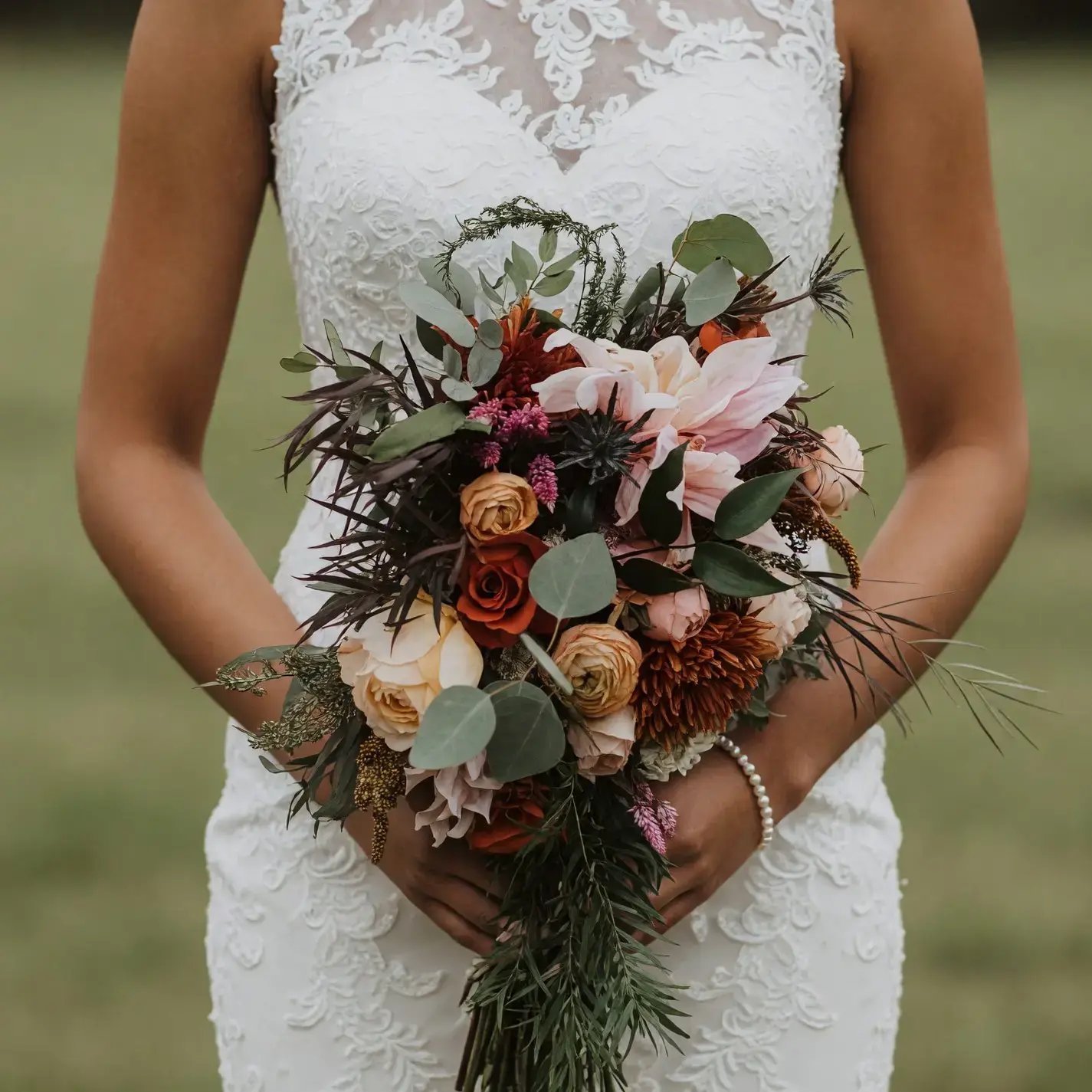 Bridal flowers bouquets with blush lilies, copper and caramel roses, bronze chrysanthemums, eucalyptus, and dark airy foliage for a fall bride