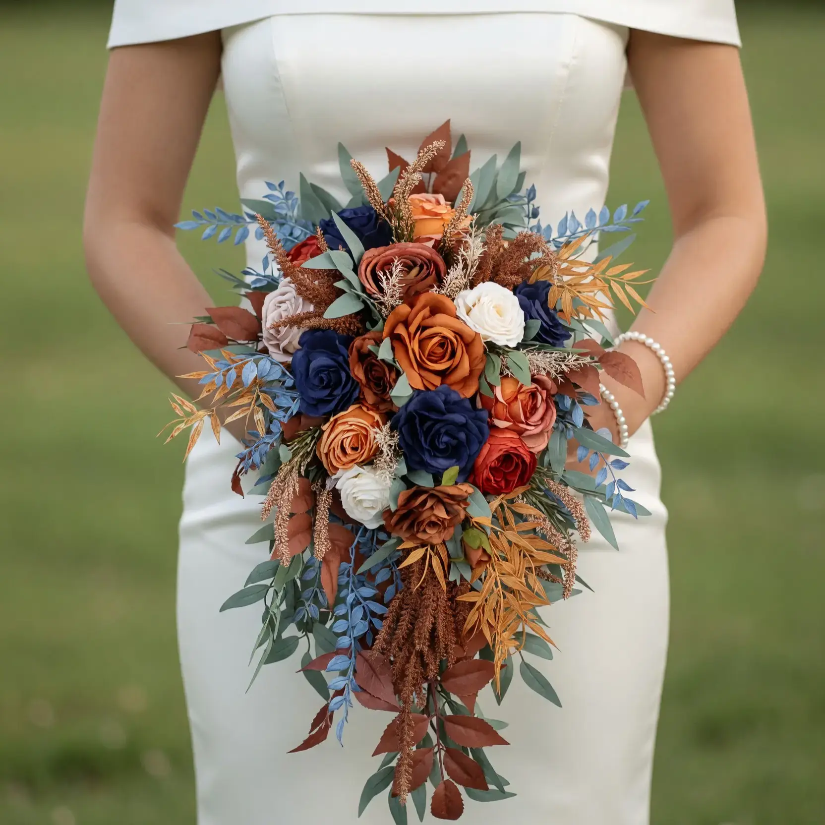 Popular wedding bouquets with navy roses, copper and rust blooms, ivory flowers, blue foliage, bronze leaves, and cascading greenery for a fall bride
