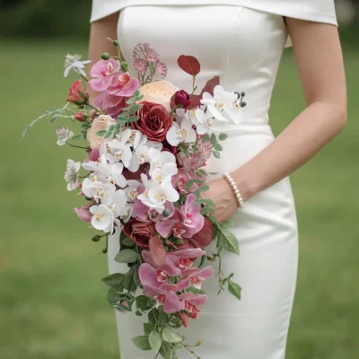 boho style flowers with burgundy roses blush orchids white orchids ivory blooms and cascading greenery for an elegant garden bride