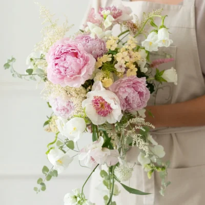 bridal blooms with blush peonies ivory flowers soft yellow accents and airy garden stems for a romantic wedding bouquet