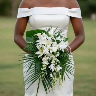 popular wedding bouquets with white orchids lilies roses cascading tropical flowers palm fronds fern and glossy green foliage