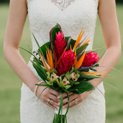 popular wedding bouquets with scarlet ginger orange bird of paradise green orchids glossy tropical leaves and sweeping grass foliage