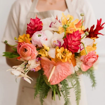 bridal flowers bouquets with coral anthurium pink ranunculus white and yellow orchids red tropical flowers and cascading fern greenery