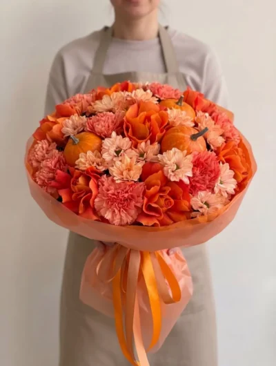 Orange flowers Vancouver Pumpkin Spice bouquet with orange roses, coral carnations, peach flowers and miniature pumpkins in tonal wrapping.