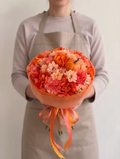 Orange flowers Vancouver Pumpkin Spice bouquet with orange roses, coral carnations, peach flowers and miniature pumpkins in tonal wrapping.