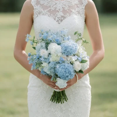 Luxury bridal flowers bouquets featuring powder blue hydrangeas, elegant ivory roses, delicate blue garden blossoms, white flowers, and fresh greenery